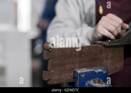 Close up of carpenter's hand using planer in wood workshop Stock Photo