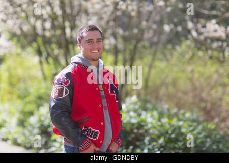 Portrait of high school senior wearing jacket in park Stock Photo