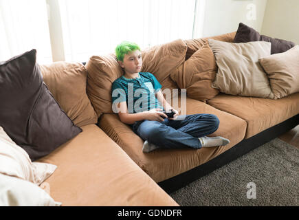 Boy playing video game on sofa Stock Photo