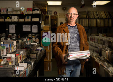 Portrait of mature man in record shop, holding records Stock Photo