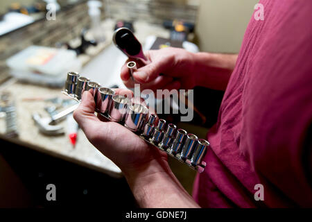 Man's hands selecting socket wrench to repair bathroom Stock Photo