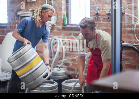 Colleagues in microbrewery cleaning beer kegs Stock Photo