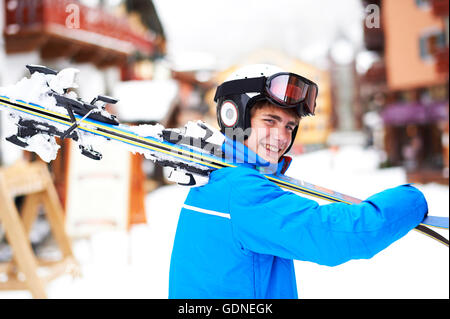 Portrait of teenage boy carrying skis on shoulder Stock Photo