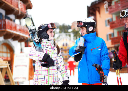 Teenager girl and boy, carrying skis Stock Photo