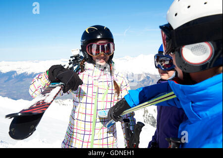 Three teenagers carrying skis Stock Photo