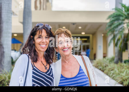 Mother and grown up daughter looking at camera smiling Stock Photo