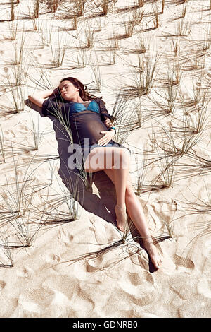 Pregnant model posing on the sandy background Stock Photo