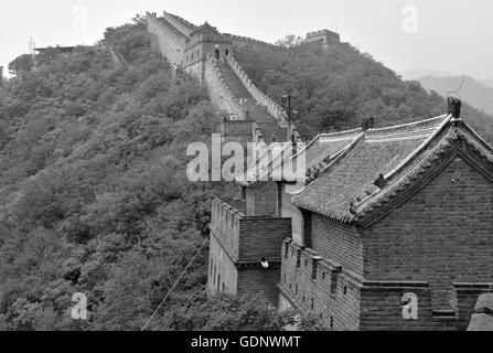 Great Wall of China atop the mountains in the forest, showing air pollution and smog, China Stock Photo