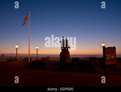 Silhouettes of statue of Lewis and Clark at the Turnaround on the Promenade in Seaside, Oregon, at sunset. Stock Photo