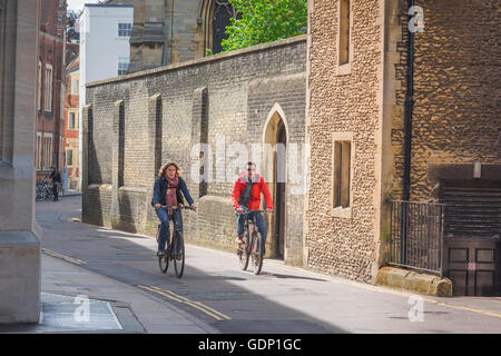 Cambridge students cycling, view of two university students cycling along Queens' Lane in Cambridge, England, UK Stock Photo
