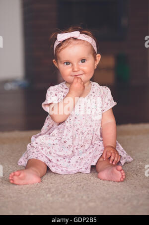 Little baby girl sitting on the floor Stock Photo