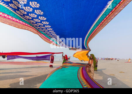 West Bengal, India - January 14, 2015: Indian women pilgrims drying their colorful sarees under sun after taking holy bath. Stock Photo