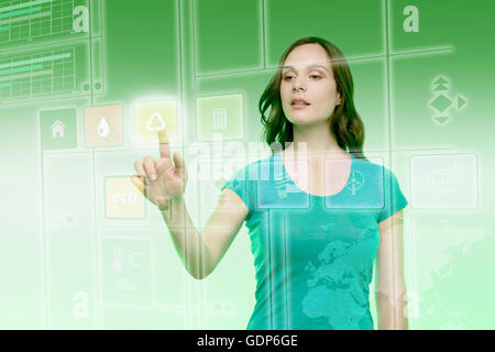 Young woman touching recycling icon on graphical screen Stock Photo