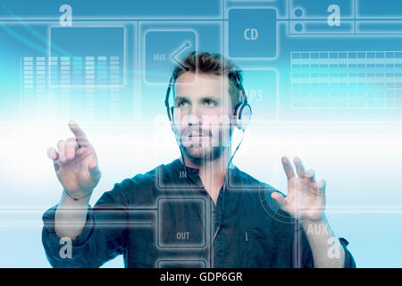 Young man wearing headphones, using graphical screen to play music Stock Photo