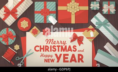 Preparing for Christmas and wrapping gifts, wrapping paper rolls, gift boxes, scissors and ribbons on a desk, top view Stock Vector