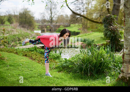 Pregnant woman outdoors, in yoga position Stock Photo