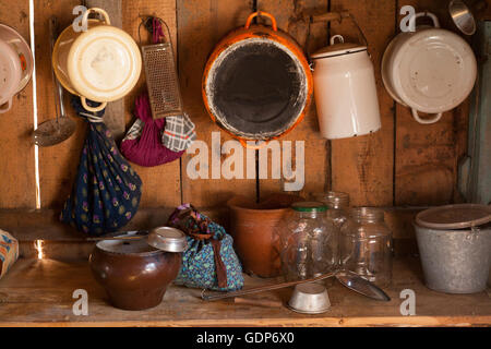 Traditional wood kitchen with saucepans, jars and utensils on shelf Stock Photo