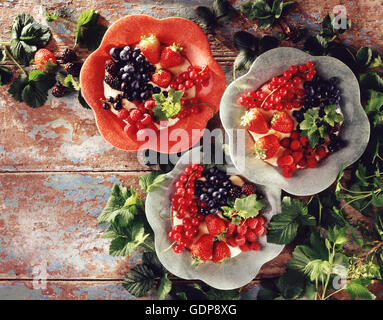 Fruit desserts, with mixed berries, on rustic wooden table, overhead view