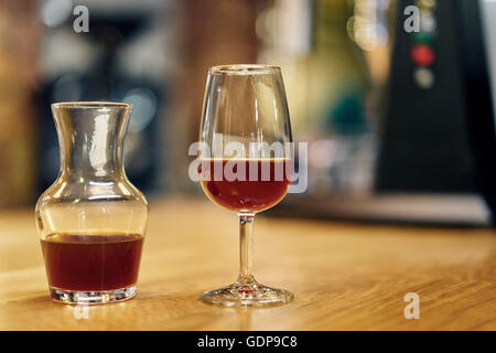 Decanter and wine glass of cold brew coffee on coffee shop counter Stock Photo