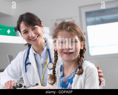 Pediatrician and girl looking at camera smiling Stock Photo