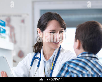 Doctor smiling at boy Stock Photo