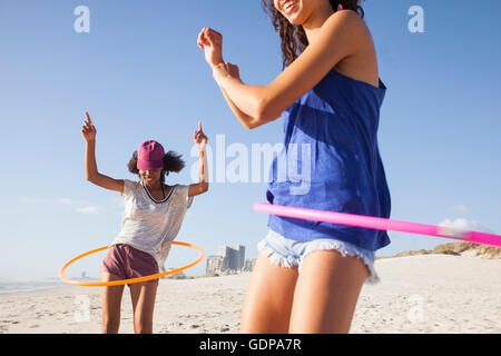 Women on beach using hula hoops Stock Photo