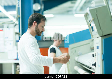 Colleagues working in launderette Stock Photo