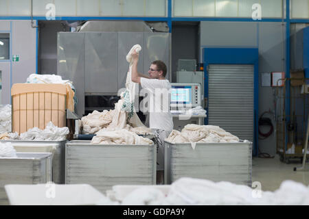 Man working in launderette sorting laundry Stock Photo