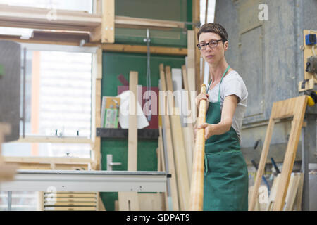 Woman in workshop checking alphorn tube Stock Photo