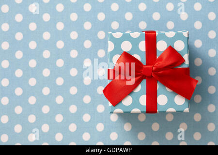 Polka dot gift box on blue dotted background Stock Photo