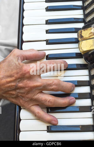 Details of a hand on an old accordion while playing. Selective focus. Stock Photo