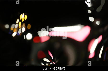 Distorted reflections of lights in the night on a fun house mirror. Stock Photo