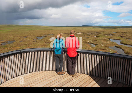 Young couple looking over peatland pools from the viewing tower on the RSPB Dubh Lochan Trail, Forsinard, Sutherland, Scotland. Stock Photo