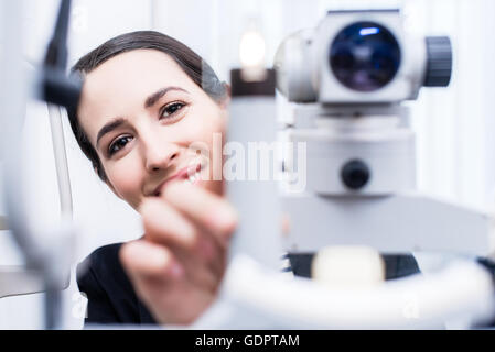 Optician attempting eye measuring with Refractometer Stock Photo