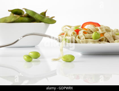 Edamame Bean Fettuccine and fresh Edamame Beans garnished with red Peppers Stock Photo