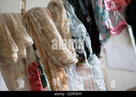 A collection of lace fabric of various colors and designs on a clothesline. Stock Photo
