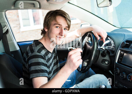 Teenage boy and new driver behind wheel of his car Stock Photo