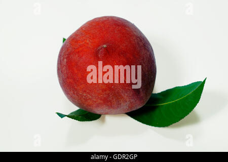 Ripe peach fruit with green leafs isolated on white background Stock Photo