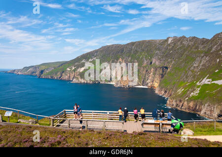 Tourists look out at Atlantic Ocean from Slieve League cliffs in County Donegal, Ireland. Stock Photo