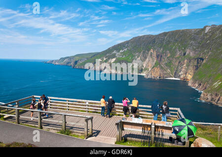 Tourists look out at Atlantic Ocean from Slieve League cliffs in County Donegal, Ireland. Stock Photo