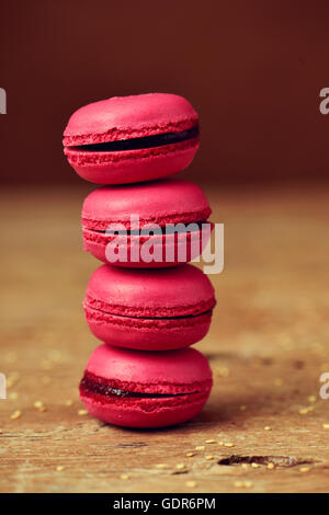 a stack of appetizing red macarons on a rustic wooden surface Stock Photo
