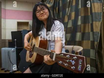 North korean teen defector in yeo-mung alternative school playing guitar, National capital area, Seoul, South korea Stock Photo