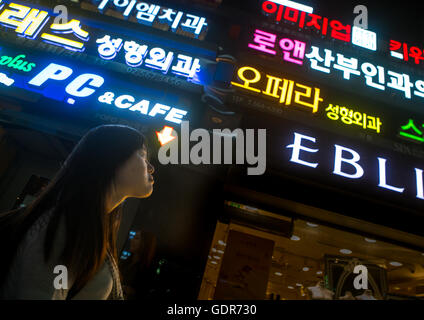 North korean teen defector in front of neon lights in the street, National capital area, Seoul, South korea Stock Photo