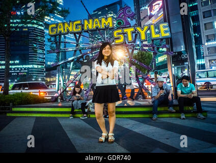 North korean teen defector in front of a gangnam style logo dancing like psy, National capital area, Seoul, South korea Stock Photo