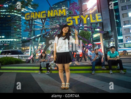 North korean teen defector in front of a gangnam style logo, National capital area, Seoul, South korea Stock Photo