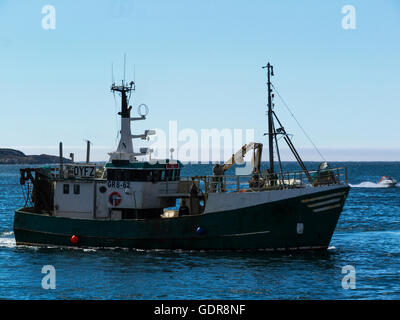 Fishing boat leaving Sisimiut harbour into Davis Strait of Disko Bay West Greenland from an Inuit fishing community on a lovely July summers day Stock Photo