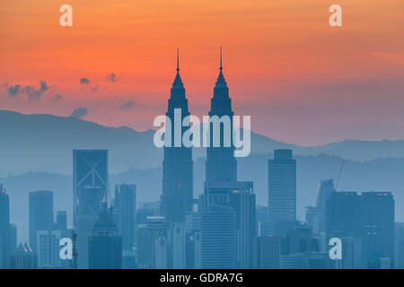 Kuala Lumpur cityscape at dawn, orange sky. Layered ground fog. Viewed from west of Kuala Lumpur Stock Photo