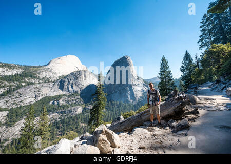 Hiker on trail to Glacier Point, Outlook on Liberty Cap, Mt. Broderick and Half Dome, Yosemite National Park, California, USA Stock Photo