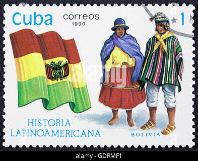 CUBA - CIRCA 1990: A stamp printed in Cuba, shows Flag and a couple dressed in national costumes from Colombia, with inscription Stock Photo