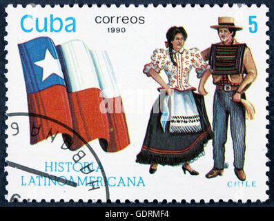 CUBA - CIRCA 1990: A stamp printed in Cuba, shows Flag and a couple dressed in national costumes from Colombia, with inscription Stock Photo